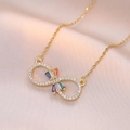Goldene Unendlichkeitskette mit bunten Zirkoniasteinen auf rosa Seidenhintergrund - Gold Mit Bunten Strasssteinen