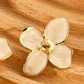 Macro shot of light pink enamel four-leaf flower studs with golden stainless steel edges - White