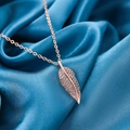 Rose gold titanium leaf necklace with shimmering zircon crystals on blue silk - Gold