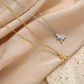 Detalle de colgantes de libélula en oro y plata con cristales sobre tela rosa suave - Estilo Libélula Diamantes de Imitación Refinado