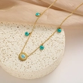 Detail of gold titanium evil eye necklace with blue charms on white textured display - Evil Eye Round Blue Enamel Style