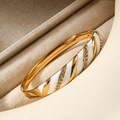 Bracciale a quadrifoglio in oro con smalto bianco e micro cristalli su lino - bianco dorato