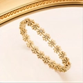 Detailed view of a gold daisy bracelet with sparkling crystal centers and relief craftsmanship - Gold
