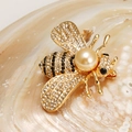 Detailaufnahme der Bienenbrosche mit funkelnden Strasssteinen und Champagnerperleneinlage - Gold