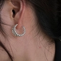 Orecchino a cerchio a C in argento con texture granulare indossato da una modella - Silver (Fixed Beads)