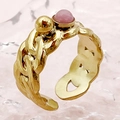 Détail d'une bague chaîne dorée avec une pierre rose sur fond texturé rose poudré - Style Maille Gourmette Cabochon Pierre Gemme (R0324-02-pink) / Rose