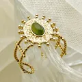 Gros plan détaillé sur bague soleil en acier inoxydable rétro avec pierre verte et fini doré - Style Tournesol (R0260-02-green) / Vert