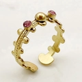 Détail d'une bague multicouche dorée avec pierres de zircon rose et perles - Rose
