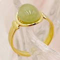 Gros plan d'une bague ajustable dorée ornée d'une pierre ovale verte et détails rainurés - Taille unique / Style Émeraude / Vert