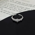 Macro shot of silver zircon star leaf ring on black reflective surface with book background - Center Main Stone Five Stone Star Style (JZ3673A)