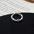 Detailed macro shot of a silver leaf ring with blue and white zircons on black mirror - Blue White Zirconia Rhythmic Pave Style (JZ3927A)