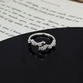 Detail of silver star ring with zircons on a black mirror surface and book background - Continuous Star Micro-Pave Zirconia Style (JZ4833A)
