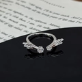 Macro view of silver star and leaf ring with zircon stones on a black reflective surface - Double Meteor Comet Mirror Polished Style (JZ5526A)