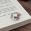 Detail eines Blumen-Schmetterlingsrings mit rosa und lila Zirkonia auf Buch - Einstellbar Offen / Blumencluster-Schmetterling (JZ3479A)