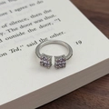 Detailansicht des lila-rosa Zirkon-Blumenrings auf einer offenen Buchseite - Einstellbar Offen