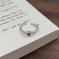Detailansicht eines silbernen Rings mit lila Herz-Zirkon und gedrehter Seilband-Texturierung - Einstellbar Offen