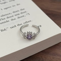 Detailaufnahme eines silbernen Blumenrings mit lila Zirkon und Mikro-Pave-Fassung - Einstellbar Offen