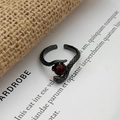 Macro shot of black gothic snake ring with red gemstone and detailed scale texture - Snake Playing With Bead Style (JZ5935)