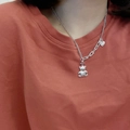 Gros plan d'un pendentif ours et cœur argenté sur une chaîne à maillons tendance - Style Ours Logo Gucci (XL0359)