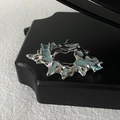 Detailansicht der silbernen Lava-Brosche mit hellblauem Emaille und quadratischen Kristallen - Unregelmäßiger Flüssigmetall-Stil (JZ2077)