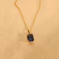 Detail eines blauen Edelsteinanhängers an einer Goldkette auf seidigem Hintergrundgewebe - 45+5cm / Blau