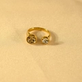 Detail van een gouden roestvrijstalen open ring met twee schitterende ronde zirkonia steentjes - Lichtgele Steen + Witte Steen