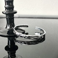 Gothic style silver open cuff bracelet with molten lava texture on black reflective surface - Lava Texture Open Bangle (JZ2588)
