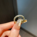 Close-up of a gold-plated eternity ring with shimmering zircon stones on a model's hand - Adjustable Open