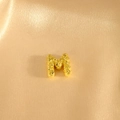 Goldener Buchstabe M Anhänger mit Glitzertextur auf feinem Champagner Satin Hintergrund - Anhänger M