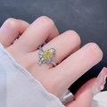Detailansicht des unregelmäßigen Vogelrings mit gelbem Zirkon am Finger und Strickärmel - Gelber Ovaler Zirkonia Stil (JZ3021)