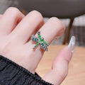 Macro view of a silver dragonfly ring with green enamel wings worn on a finger - Adjustable Open / Green Dragonfly Enamel Style (JZ3100)
