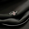 Detailaufnahme des rosa rechteckigen Edelsteinrings auf elegantem schwarzem Seidenstoff - Rosa Rechteckiger Künstlicher Edelsteinstil (JZ4092)