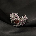 Detalle del anillo con circón rojo, montura floral y cristales color púrpura - Estilo Floral Aspecto Ámbar Marrón Oscuro (JZ4356)
