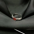 Detalle de un anillo con gema naranja ovalada y micro-pavé de cristales sobre seda negra - Estilo Abierto Zirconia Naranja Ovalado (JZ4062)