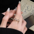 Close-up of wavy gold ring with purple gemstones and zircons on elegant card - Purple Gemstone Wave Gold Band (JZ4669)