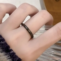 Vue macro détaillée d'une bague minimaliste en métal noir martelé portée au doigt - Style Bague Fine Facettée Noire (JZ3771)