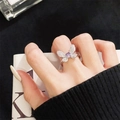Detailansicht Schmetterlingsring mit lila Stein und Zirkonia am Finger der Frau - Einstellbar Offen / Pavé Lila Hauptstein Schmetterling Stil (JZ5395)