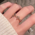 Golden ring with pear-shaped clear stone and purple zircons worn on hand near perfume - Pear Shaped Clear Stone Style (JZ5448)
