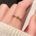 Detailed close-up of a gold star-shaped ring featuring blue and white cubic zirconia stones - Blue Star Decoration Style (JZ5670)