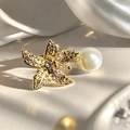Détail macro d'une bague étoile de mer dorée avec pavé de cristaux et perle sur soie - Style Étoile de Mer Perle Pavé (JZ5065)