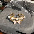 Detail eines goldenen Doppelrings mit rosa Emaille-Schmetterling und weißen Perlen - Doppelschichtiger Perlen-Schmetterlings-Stil(JZ6255)