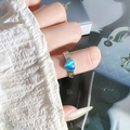 Macroshot van een blauwe hartvormige kattenoogsteen ring met getextureerde zilveren band - Verstelbaar Open / Blauw Hart Kattenoog (JZ5580)