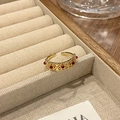 Detail van het ingewikkelde opengewerkte roosterpatroon en rode stenen op de gouden ring - Rode Steen Hol Vensterstijl (JZ4213)