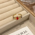 Detail van vintage gouden ring met rode steen en blauwe accenten op houten dienblad - Rood Blauwe Edelsteen Barok Gesneden Stijl (JZ4216)