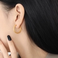 Pendientes de aro dorados con textura martillada mostrados en una modelo con estilo - 20mm / Dorado