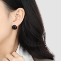 Boucles d'oreilles boules noires dorées élégantes portées par un mannequin femme - Argent Onyx Noir