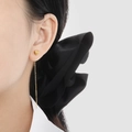 Elegant gold heart tassel earrings featuring long thin chains on a model with a dark bow - Straight Needle Style (EX0019)