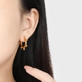 Minimalist titanium steel gold bead hoop earring shown on ear for a stylish fashion look - Gold