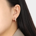 Rose gold hoop earring with star-shaped settings and colorful zircon stones on female ear - Rose Gold Color