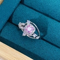 Makroaufnahme eines quadratischen rosa Edelsteinrings mit Diamanthalo auf Samtbox - Einstellbar Offen / Quadratischer Rosa Zirkon Stil (JZ2136A)